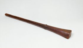 178.jpg Club made of brown wood with a handle that is slightly rhomboid shaped at one end and pointed at the other. Both ends separated by a bulged ring.