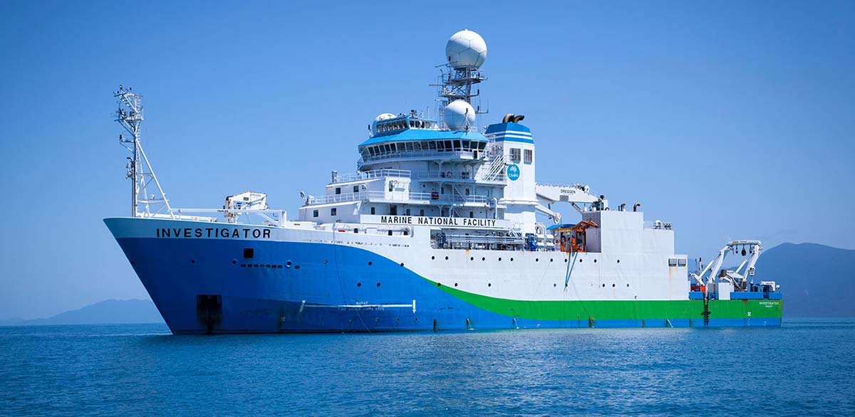 A ship at sea, equipped with radar domes and a tall apparatus on the bow.