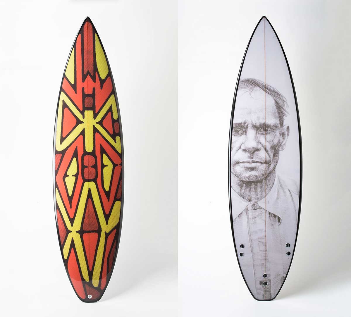 A fibreglass surfboard featuring a rainforest shield design on the front, with a portrait in black and white on the reverse.