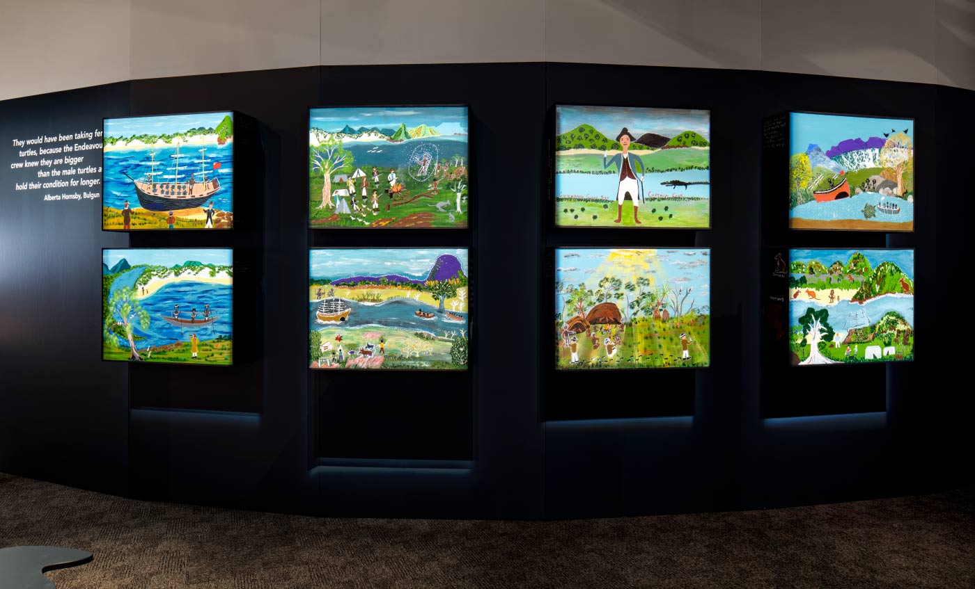 Exhibition display wall featuring light boxes with artworks.