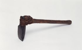 Adze to’i Small stone axe with a handle made from medium brown hardwood and a blade made of fine-grained black basalt both tied together with coconut fibre. The end of the T-shaft appears to be broken off.