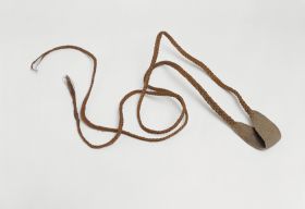 Sling ma’a A rotation sling. The pouch and cords are made as one piece, from coconut fibres, which are intertwined with other plant material and plaited into tight and firm coils.