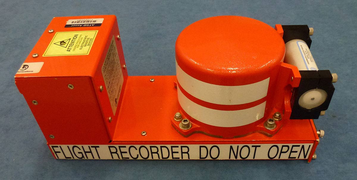 Orange device comprising box at end of a platform and circular component at other end.