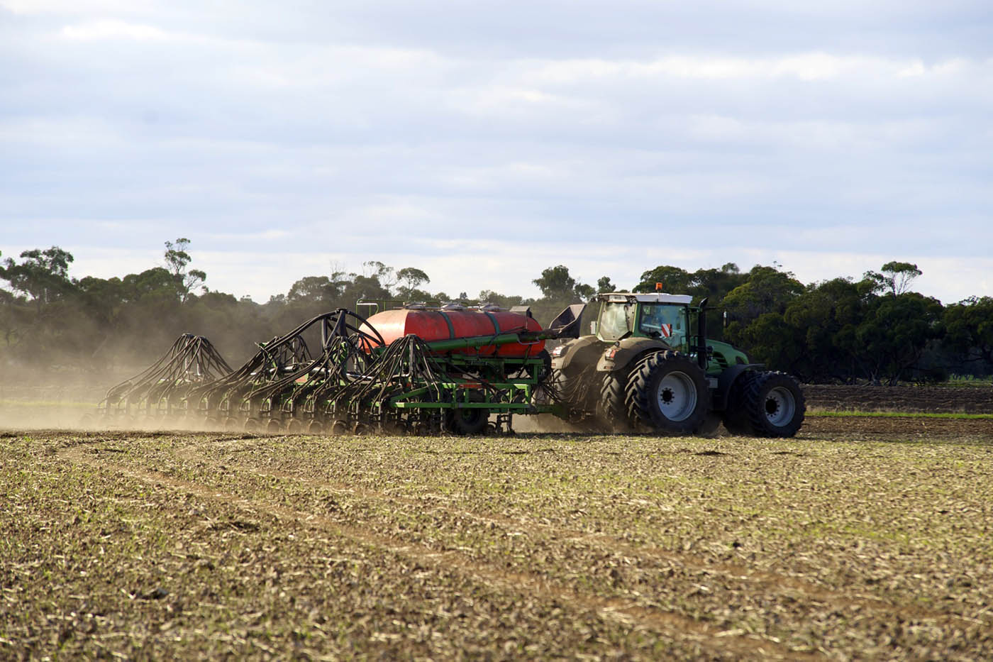A farming contractor sowing farmland.