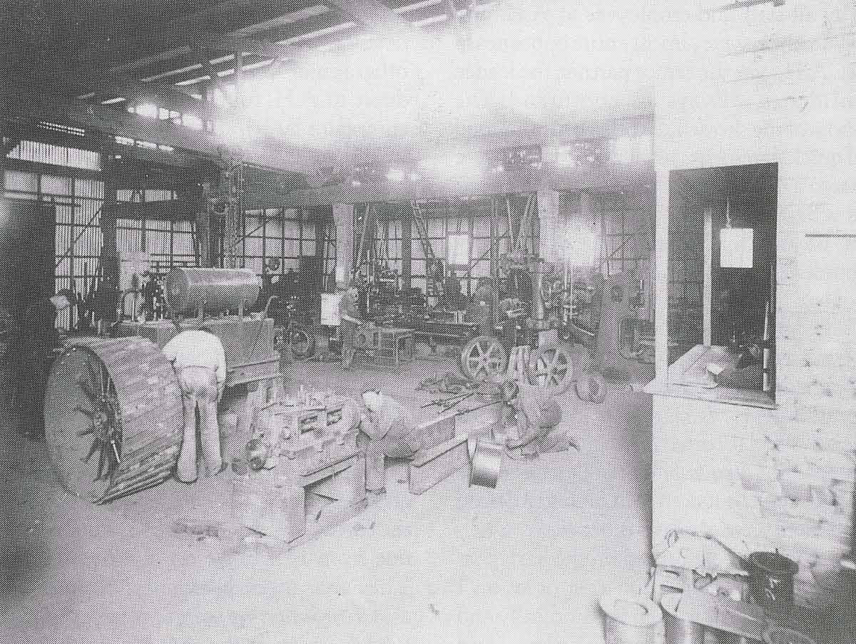 Black and white photograph of workers in a factory warehouse.