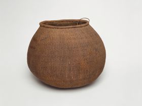 Basket Barrel-shaped basket made of woven coconut leaf ribs, sticks and plant fibre.