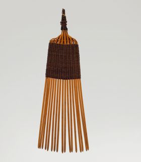 16.jpg A comb made of seventeen small sticks woven together with a 4cm long weave made of light brown and black fibres.
