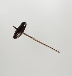 120.jpg Spinning top that is a kind of bean with a thick dark brown shell, in which a hole is made and one end of a small stick put through it.