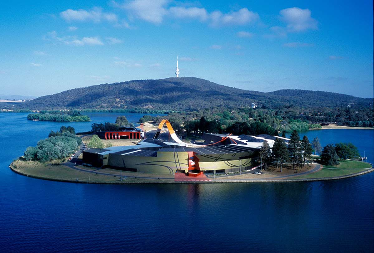 Aerial view of a modern building on a peninsula surrounded by a lake.