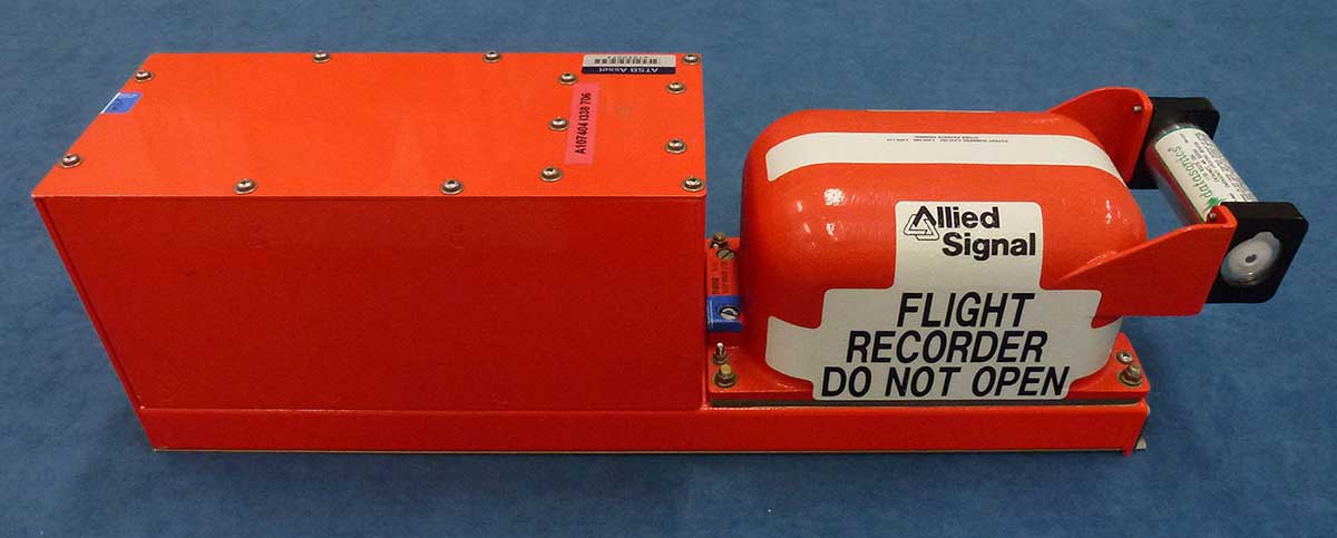 Orange device comprising longer rectangular box at one end and oblong object at other.