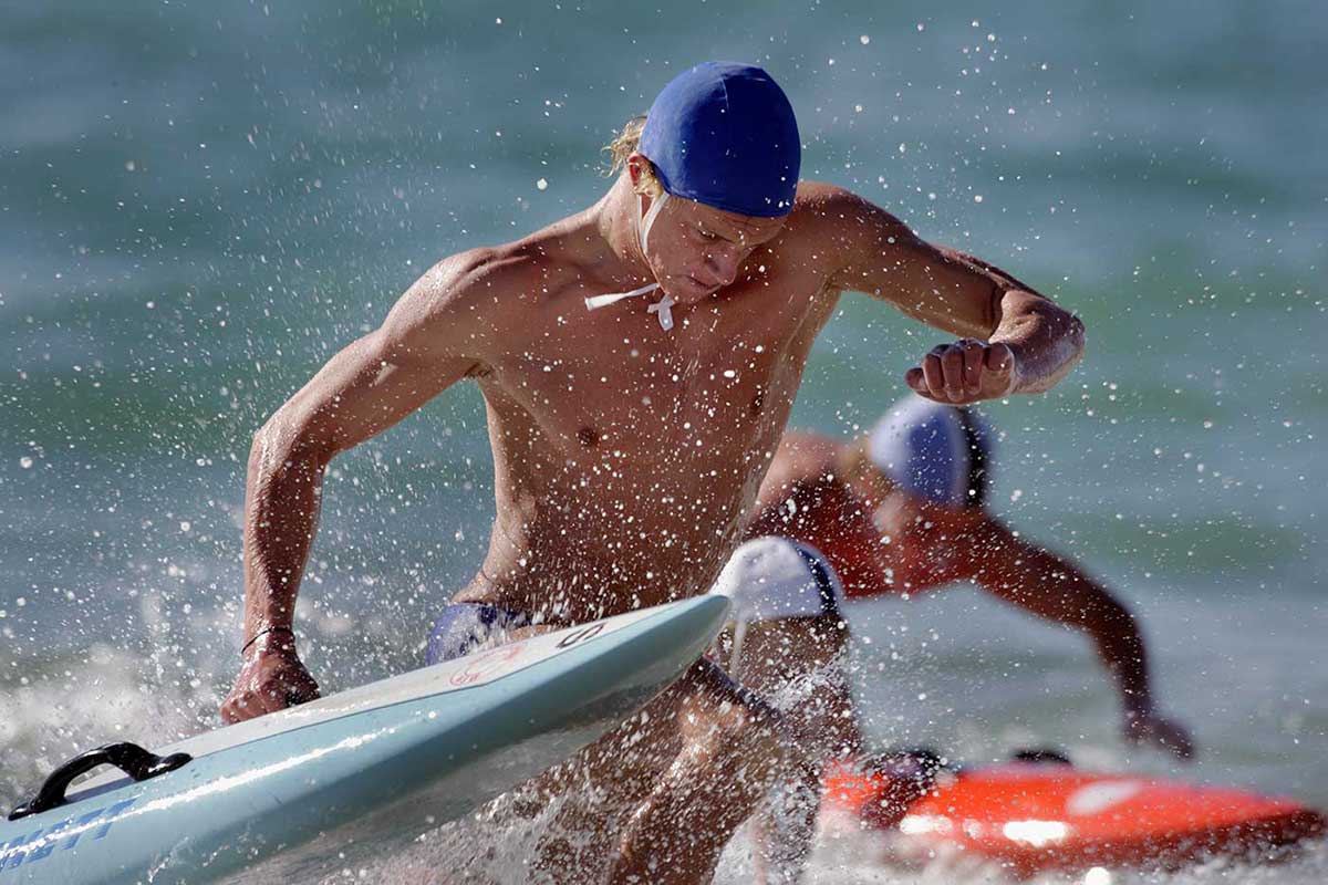 Surf livesavers in the surf with their boards at the Australian Surf Life Saving Championships, Kurrawa, Queensland, 2006.