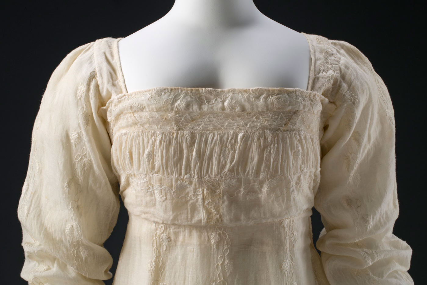 Bodice featuring a shirred band, which has an insertion of machine-embroidered net (a later alteration) at the top.