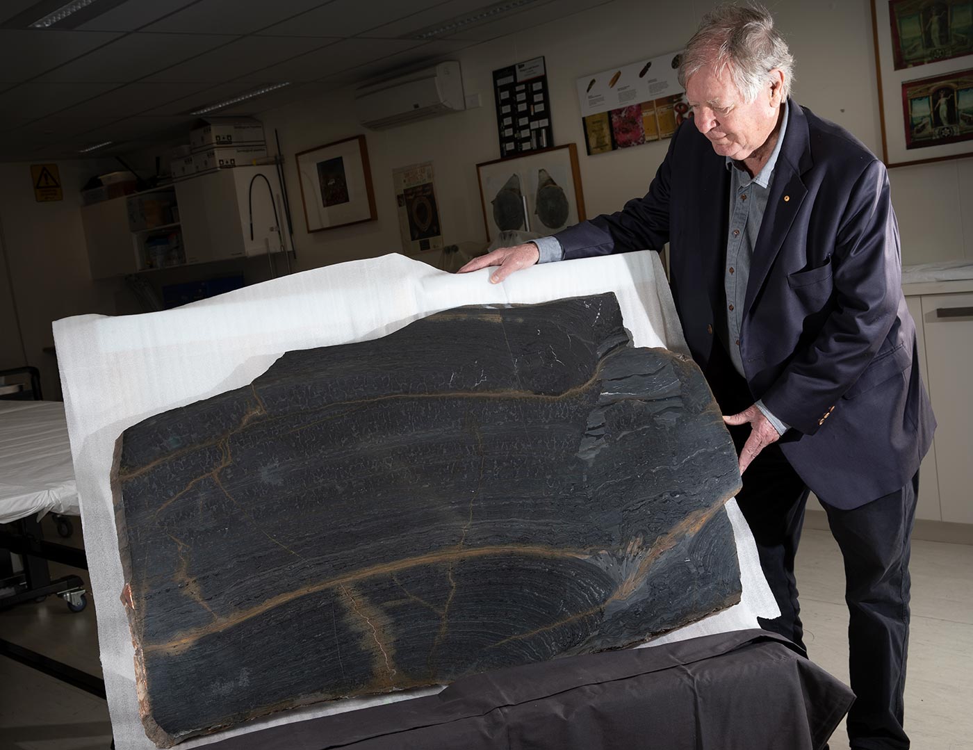 A man is displaying a very large stone artefact.