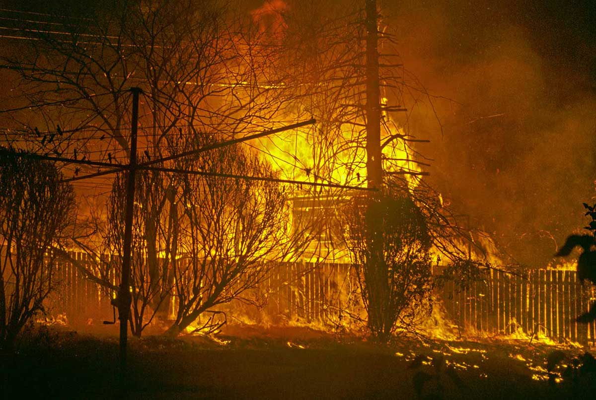A bushfire ravages through a residential area.