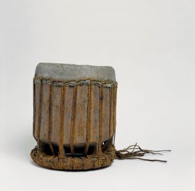 242.jpg Standing drum with zig-zag lashing. Drum skin made from shark skin fastened with plaited cord of coconut fibres stretched from the cover to the ring-like pedestal.