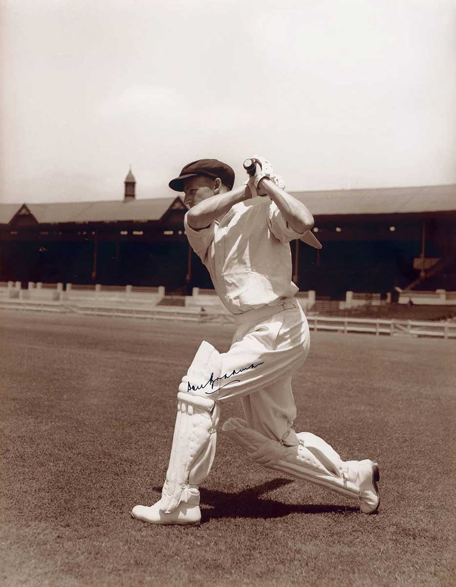 Batsman hitting ball, with stadium in background.
