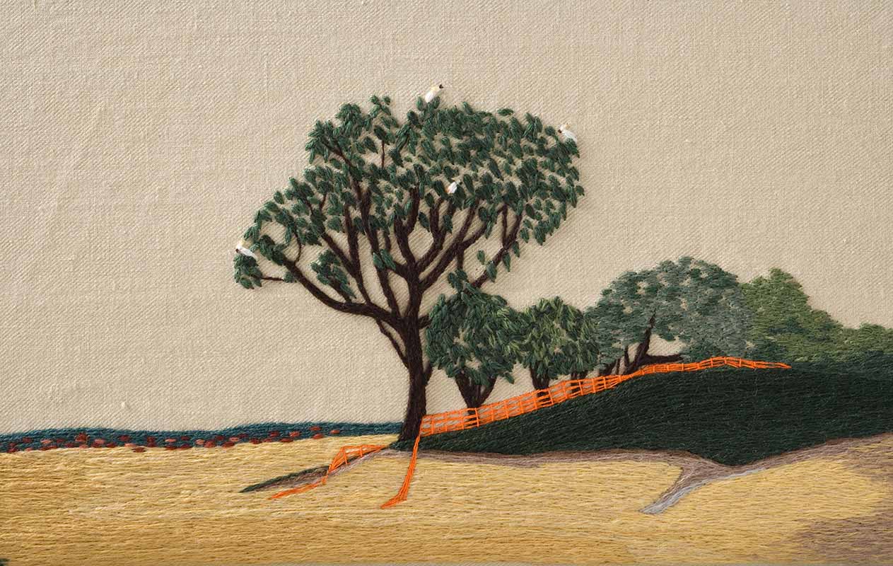 A detail of panel two of 'The Crimson Thread of Kinship' embroidery featuring four white cockatoos sitting in a tree.