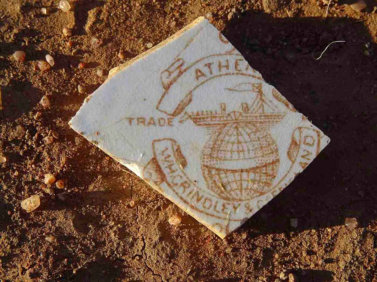Piece of broken ceramic plate showing partial trademark of its English manufacturer