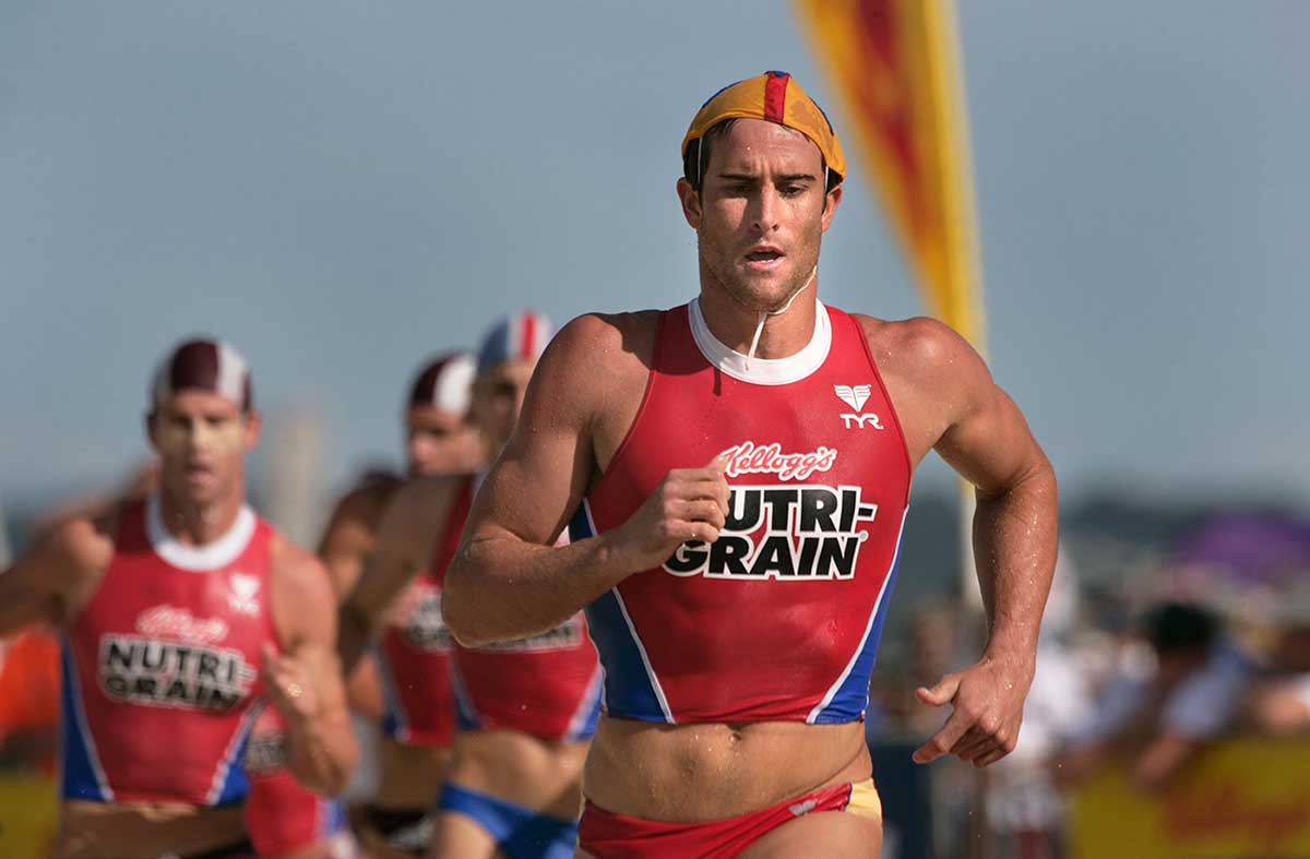 Surf livesavers running on the beach and wearing swimsuits with Kellogs Nutri-grain branding.