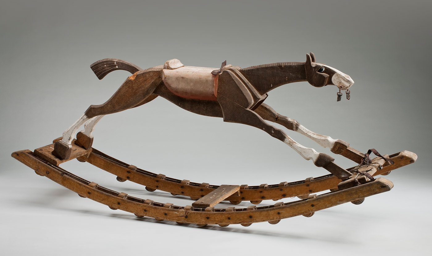 Wooden rocking horse with elliptical wheels.