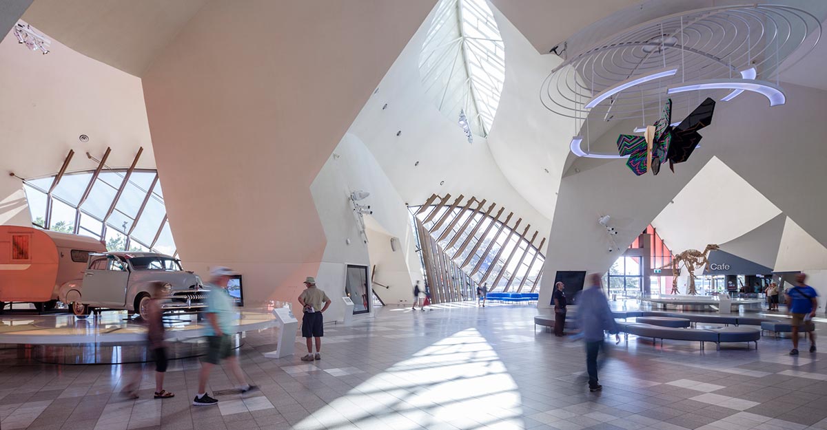 Visitors in a large atrium viewing the museum objects on display.