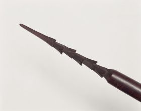 184_a.jpg Spear made of brown wood and polished. The point is 24cm long with six rows of three barbs each.