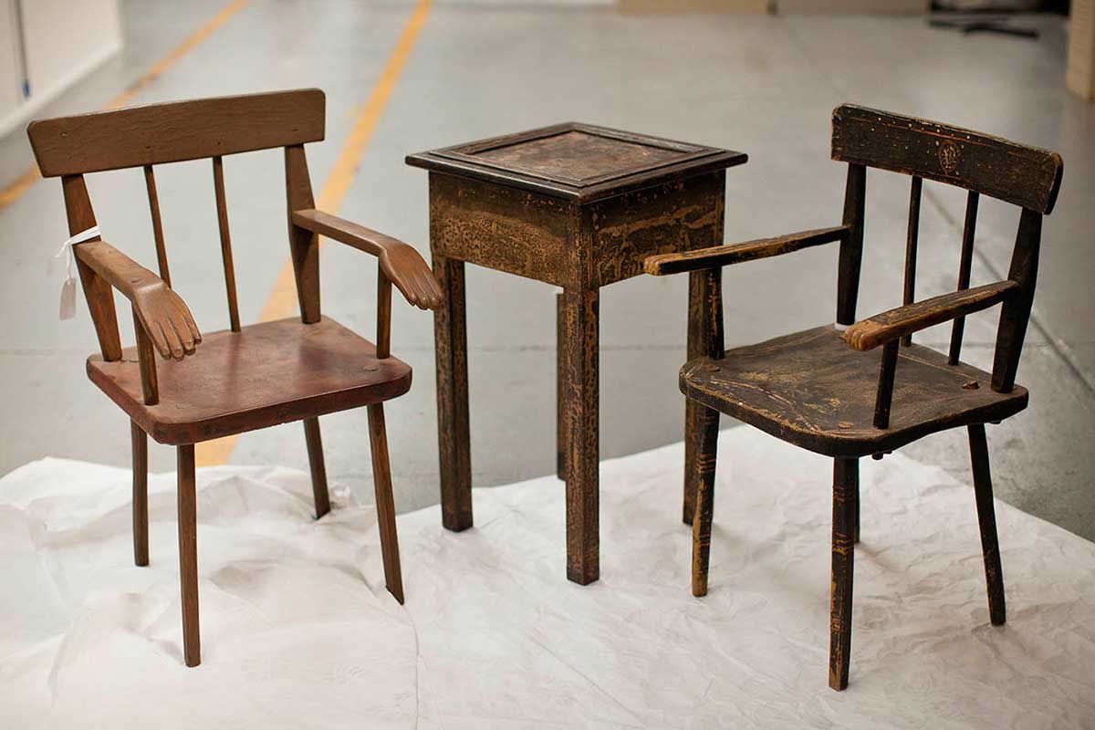 Two wooden chairs either side of a small wooden table.