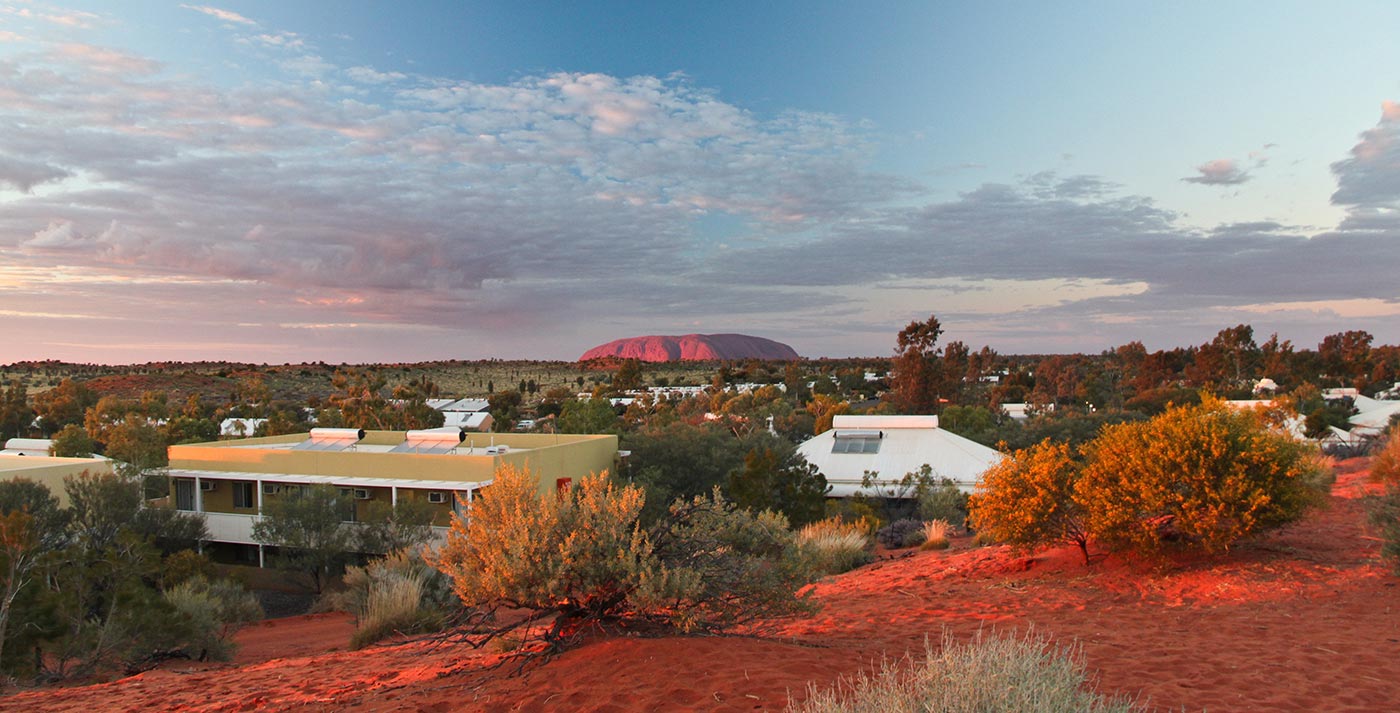 Sunset at Yulara tourist village, with the massive stone mountain Uluru, or Ayers Rock, rising in the distance, July 2011