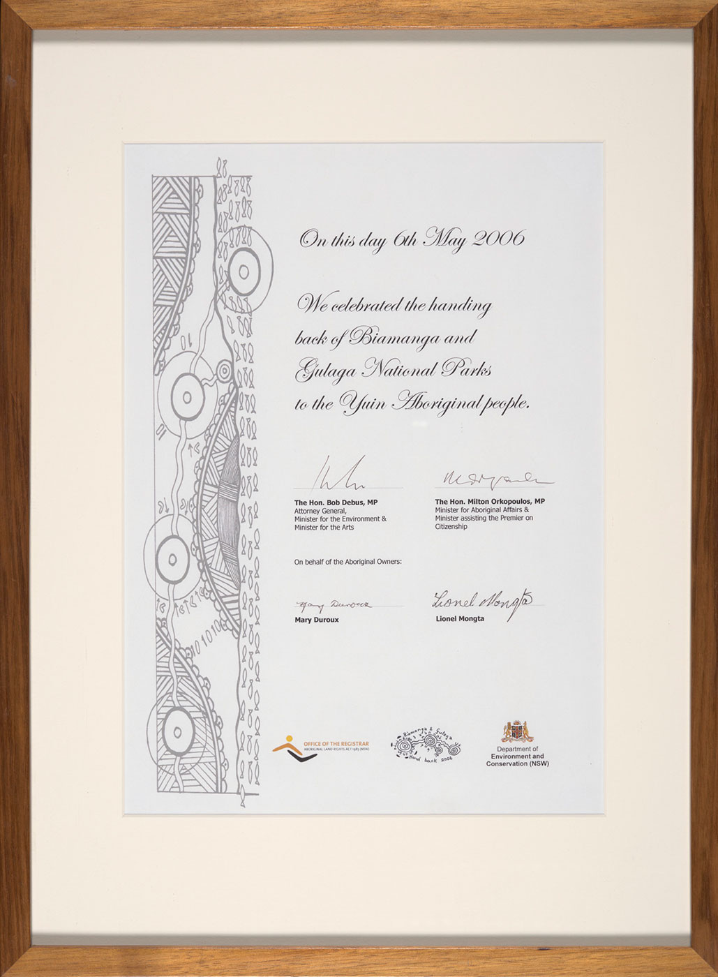 A framed certificate that reads 'On this day 6th May 2006 / We celebrated the handing / back of Biamanga and / Gulaga National Parks / to the Yuin Aboriginal people.' It is signed by 'The Hon. Bob Debus MP', 'The Hon. Milton Orkopoulos, MP', 'Mary Duroux' and 'Lionel Mongta'.