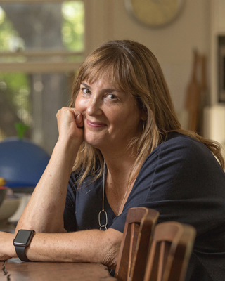 A photograph of Alex Sloan seated at a table. 