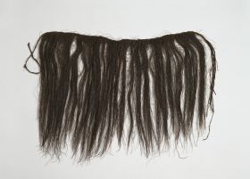 Apron liku Apron made of black plant fibres plaited into a long band.