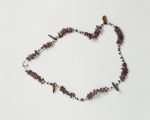 Necklace tuinga kahoa Oz 195 Necklace consisting of small white shells, small dark wooden discs, small reddish-brown snail shells and larger pieces of tortoiseshell arranged on a string.