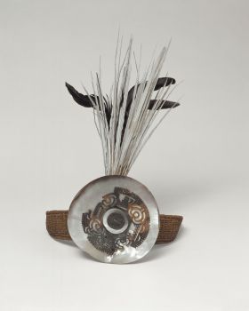 Headband uhikana Headband made of coconut fibres, interwoven, and attached to a round plate of Mother-of-pearl where long black and white tail feathers protrude behind it.
