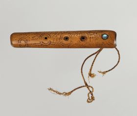 Flute koauau Flute made of light brown wood, embellished with spiral patterns in dots and lines, with a mother-of-pearl plate and three holes, at one end with the remains of a twisted cord.