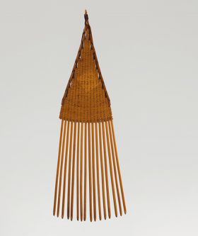 14.jpg A comb made of sixteen small sticks held together by a weave of light brown fibres.