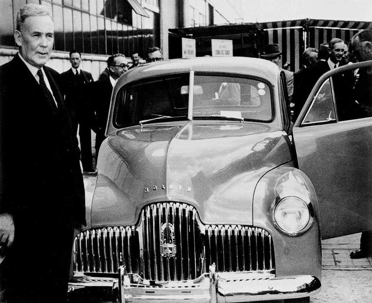 Black and white photo of Ben Chifley with a Holden car.