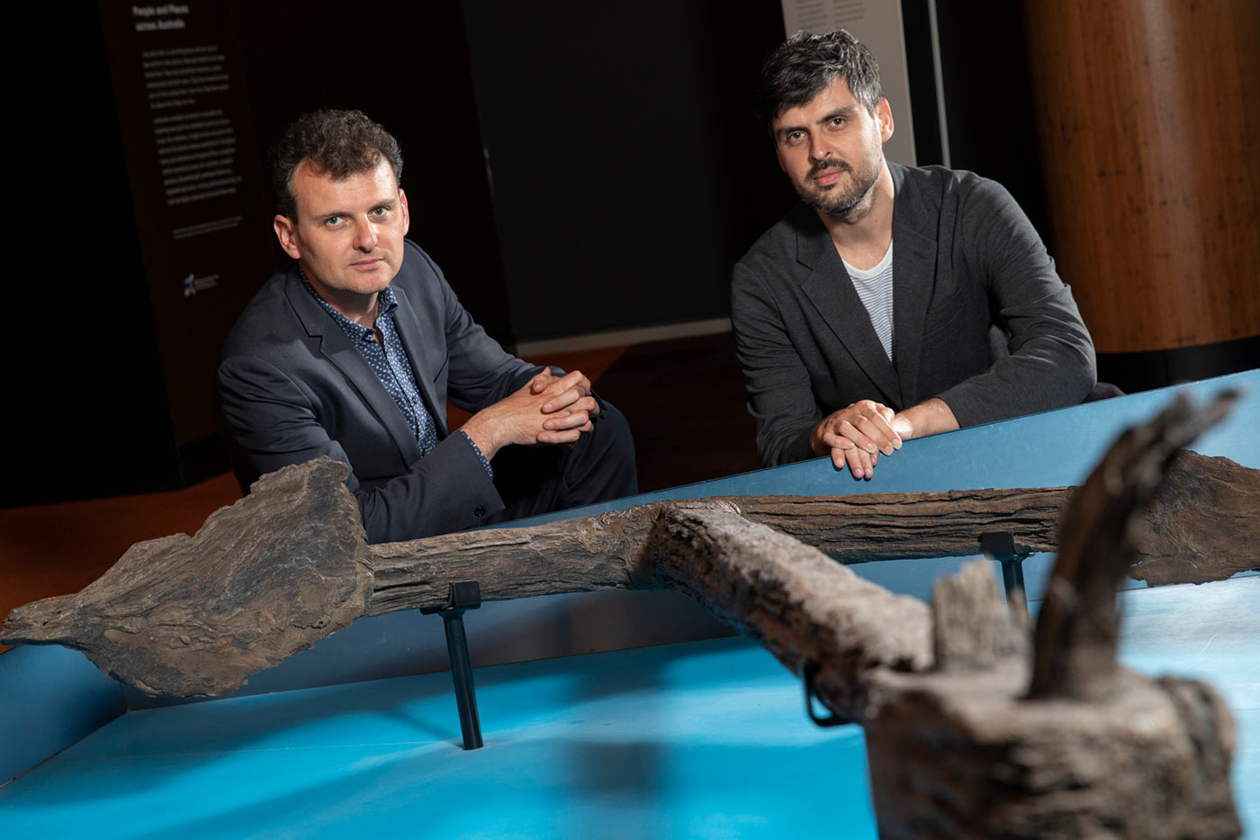 Slava and Leonard Grigoryan kneel near a large anchor on display.