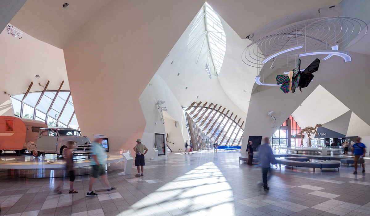 Visitors in a large atrium viewing the museum objects on display.