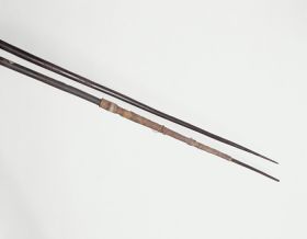 186_b.jpg Wooden spears that are thin at the lower end and gradually thicken to an engraved pattern. One spear is bound near the point with bark cloth.