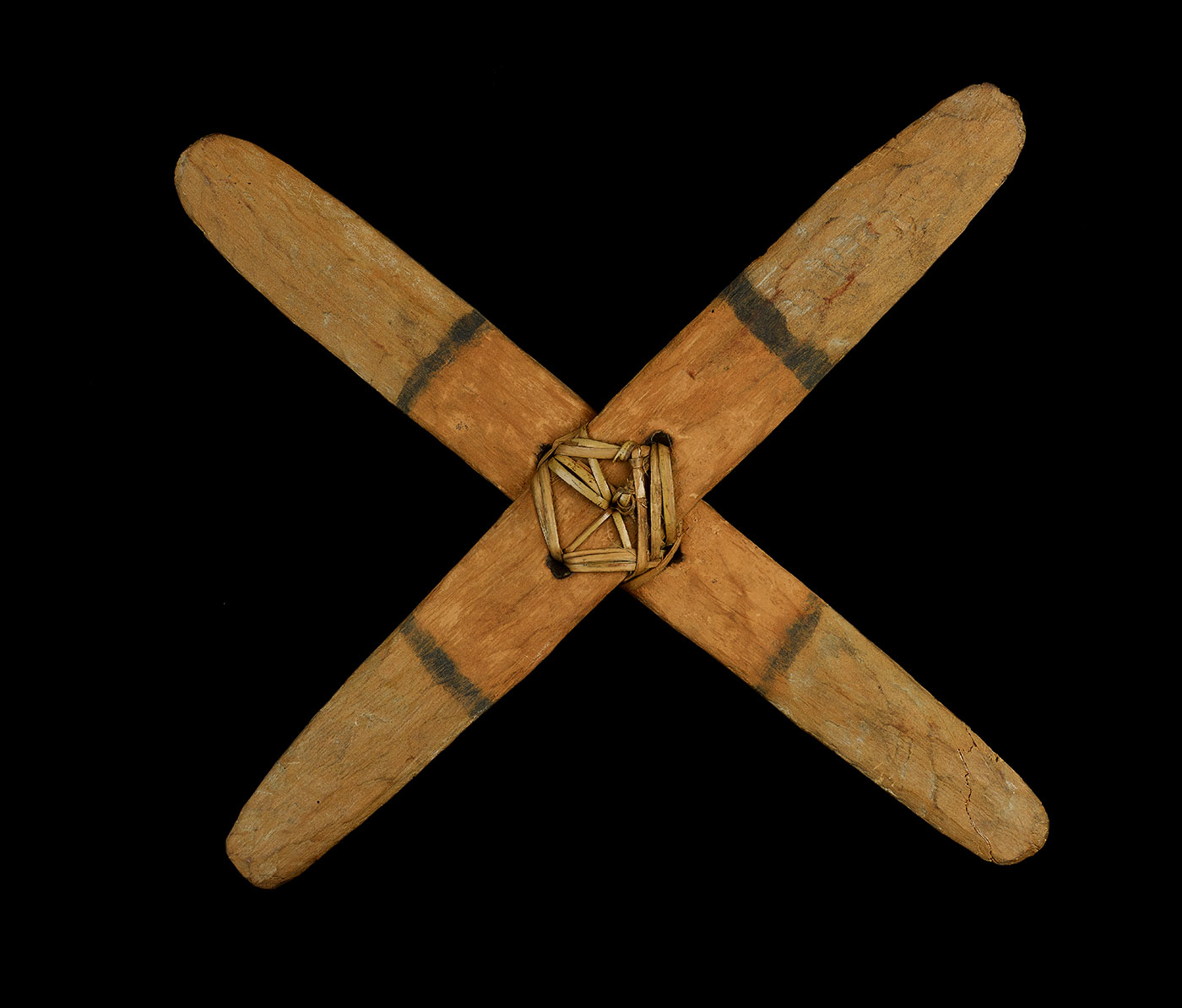 Two flat pieces of wood with rounded ends, secured in a cross shape with fibre threaded through holes.