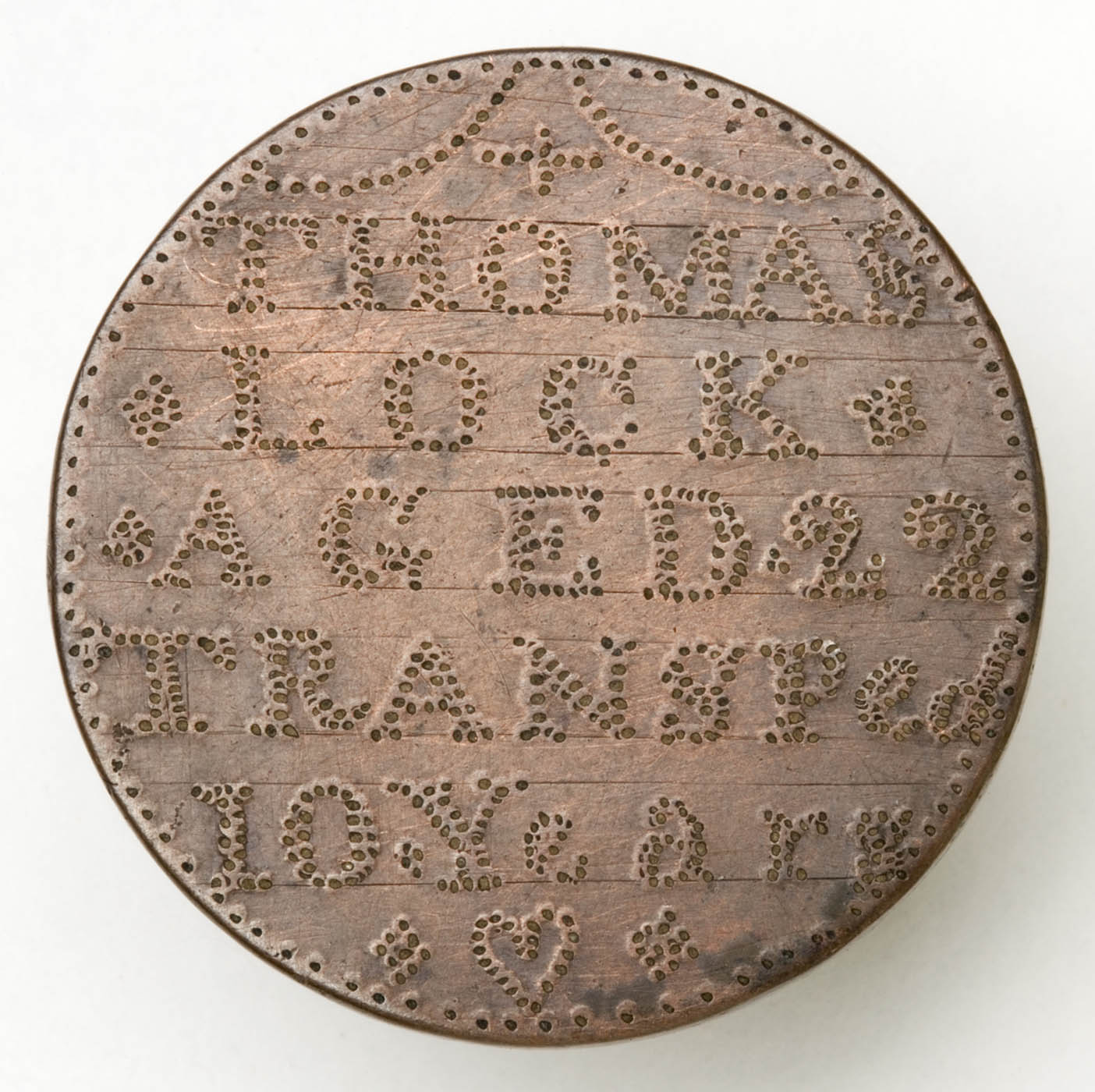 Rusty looking token with embossed letters.