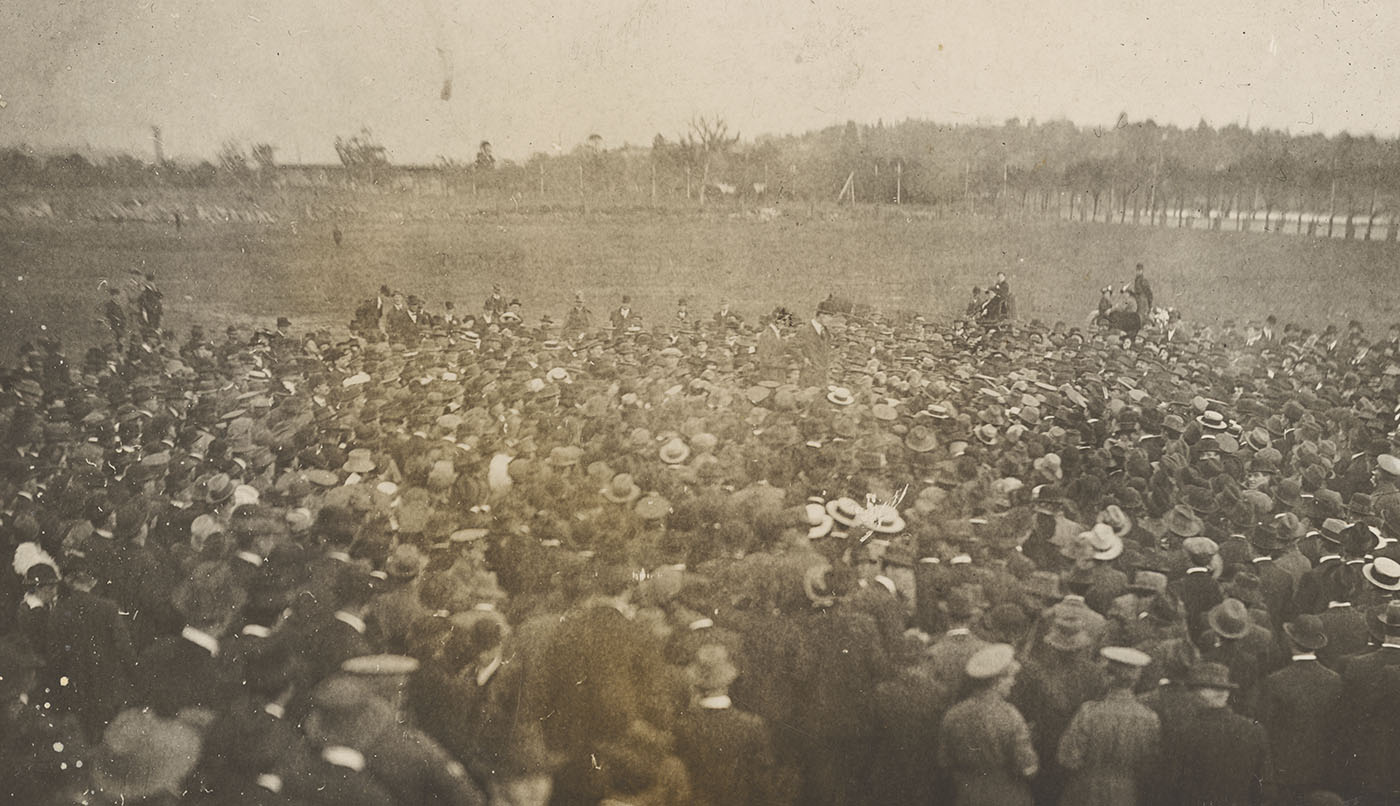 Black and white photo of a huge crowd of people in a field.