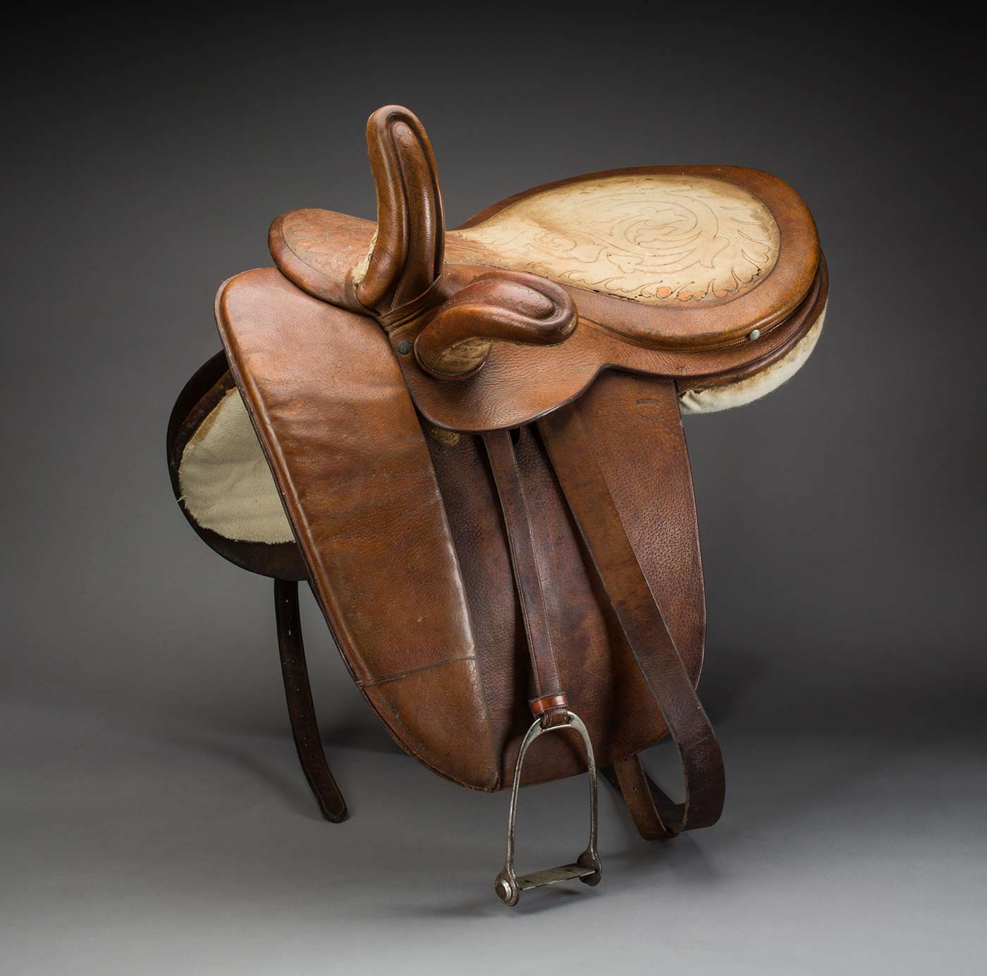 A leather side-saddle, with a pattern tooled into the seat.