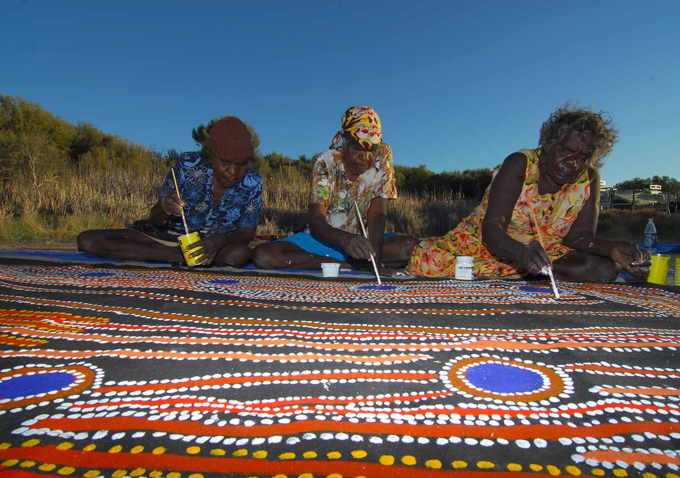 (left to right) Rosie Williams, Dulcie Gibbs and Muni Rita Simpson, from Martumili Artists, working on Minyipuru (Seven Sisters).