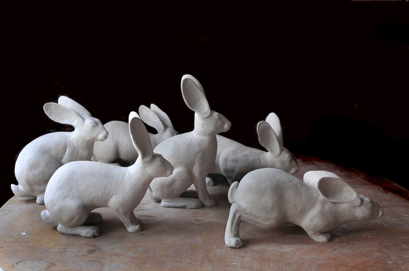 Six matt white ceramic figures modelled on the European wild rabbit.