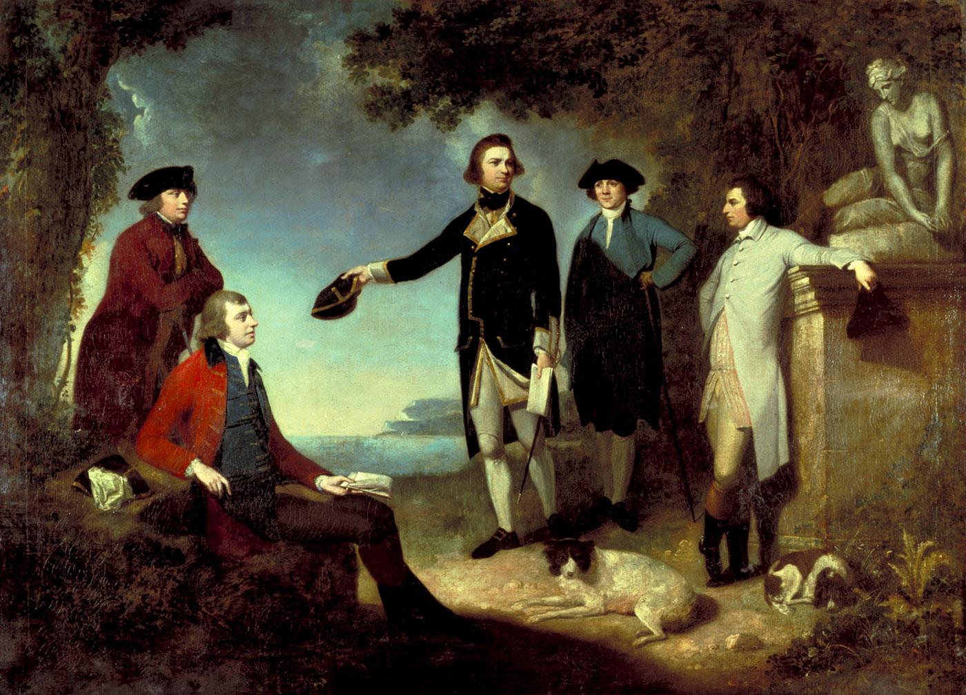 Oil painting showing five men in an Arcadian landscape, with a marble statue of a seated woman at right and two dogs lying at the men's feet. The man at centre gestures towards a bay.