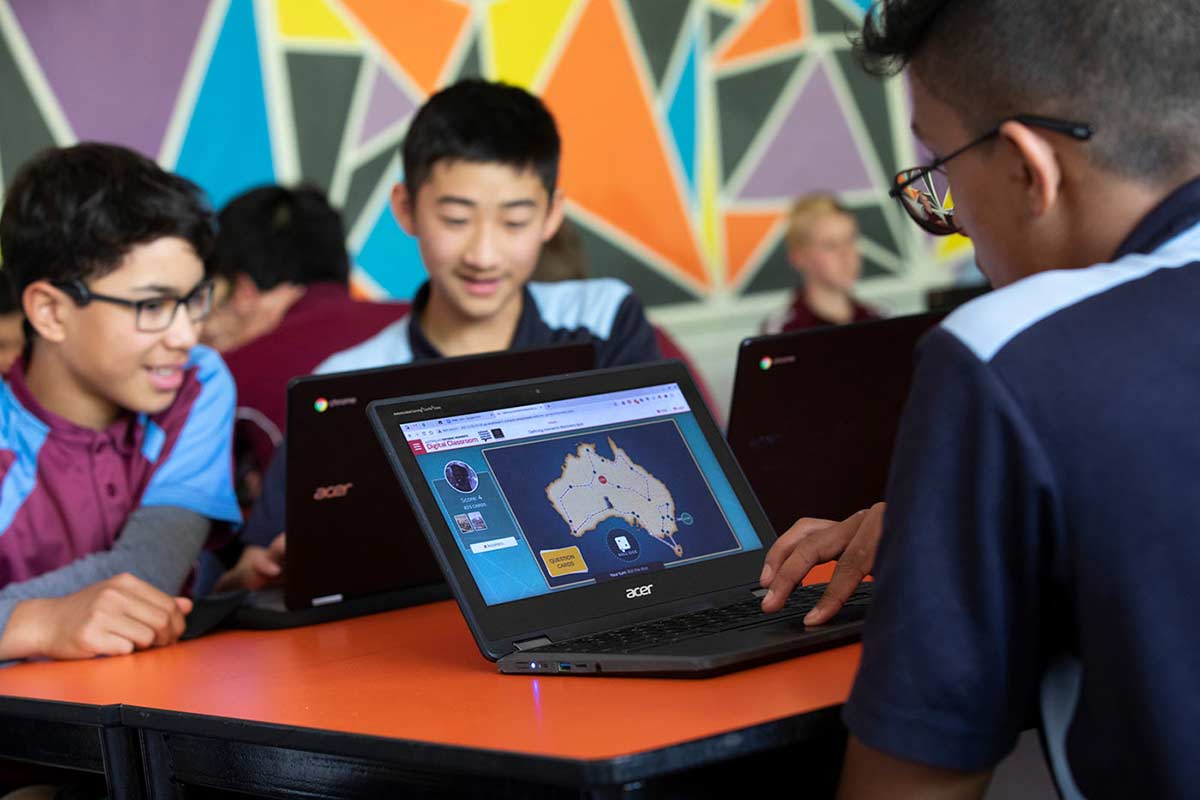 School children in a classroom with digital devices.
