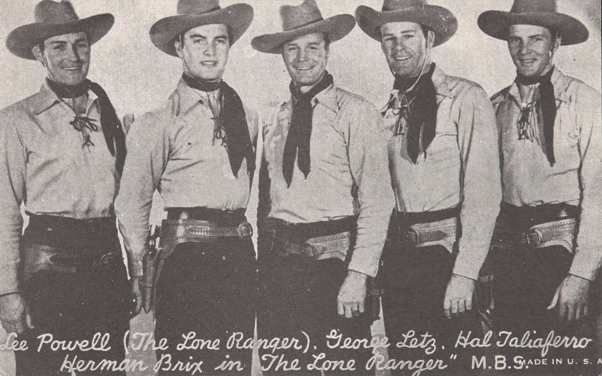 A postcard featuring a black and white photograph of five men dressed as cowboys with hats, handkerchiefs around their necks and gun holsters around their hips. Printed text at the bottom of the image reads