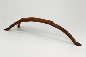Headrest kali Headrest made of a hard wood and used as a pillow. A semi-circular piece with a flat, rectangular upper surface. One side forms one leg and the other divides into two legs.