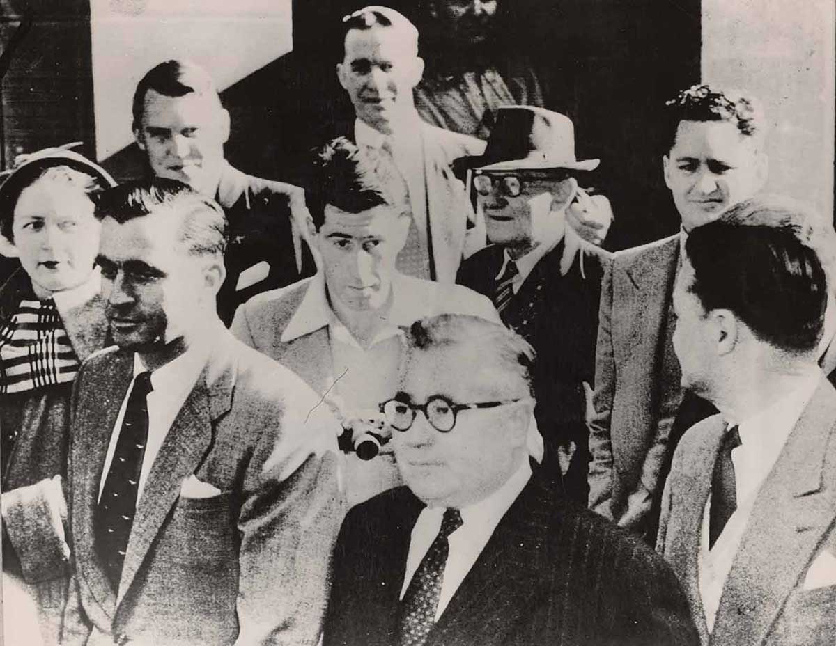 Black and white photo of one woman and eight men.